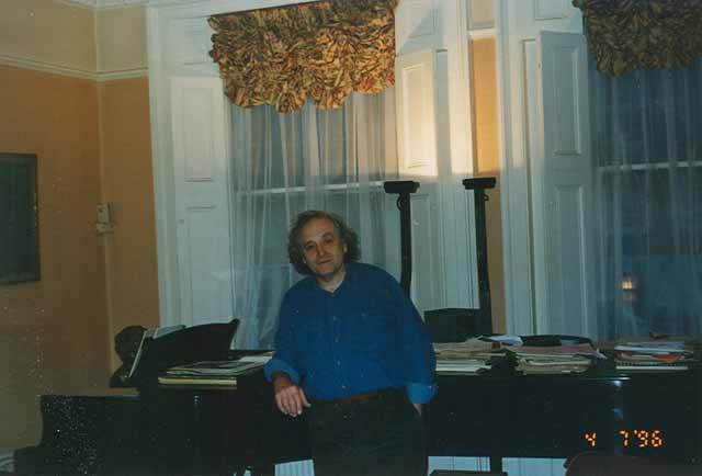 Yonty Solomon standing in front of his piano